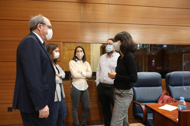 El portavoz del PSOE en la Asamblea de Madrid, Ángel Gabilondo (i), mantiene una conversación con la portavoz de Unidas Podemos-IU en la Asamblea de Madrid, Isa Serra (d), durante una sesión plenaria en la Asamblea de Madrid (España), a 15 de octubre de 2