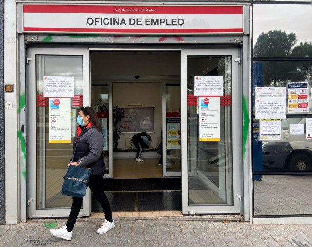 Una mujer sale de una oficina de empleo
