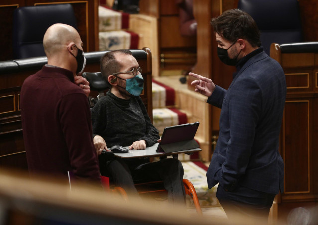 (I-D) El diputado de Unidas Podemos, Txema Guijarro; el portavoz de Unidas Podemos en el Congreso, Pablo Echenique, y el portavoz adjunto de ERC, Gabriel Rufián, charlan durante una sesión plenaria
