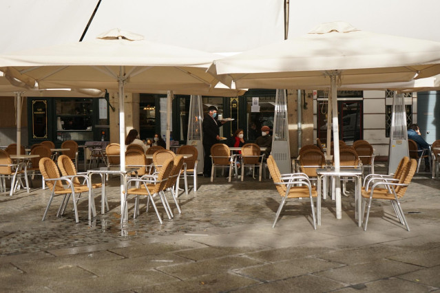 Dos personas disfrutan en la terraza de un establecimiento el mismo día de la reapertura de la hostelería tras la relajación de las restricciones decretadas por la Junta para las provincias de Ávila y Segovia, en Segovia, Castilla y León