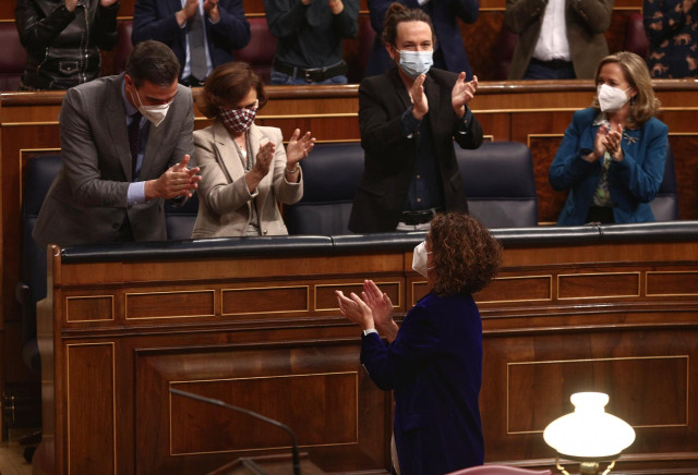 El presidente del Gobierno, Pedro Sánchez, y la ministra de Hacienda y portavoz del Gobierno, María Jesús Montero (abajo), aplauden la aprobación de los Presupuestos en el Congreso