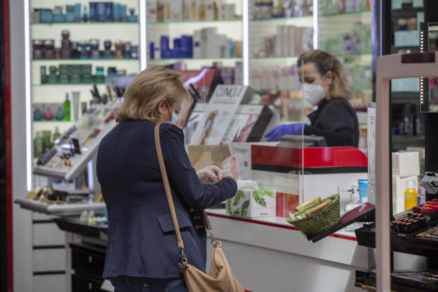 Una mujer comprando en una perfumería