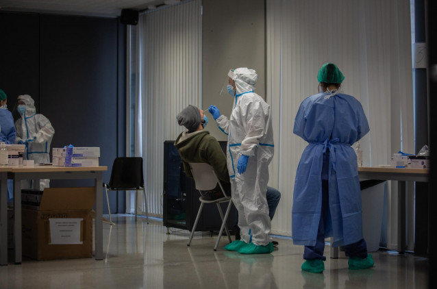 Un hombre recibe una prueba PCR en un dispositivo de cribado.