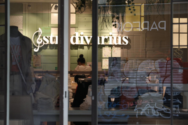 Una trabajadora protegida con mascarilla coloca los productos en una tienda de Stradivarius perteneciente a la marca Inditex que desde este jueves, algunas de sus tiendas de menos de 400 metros cuadrados de sus diferentes marcas en distintos puntos de la