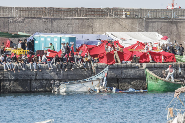 Varios inmigrantes en el Muelle de Arguineguín, en Gran Canaria, Canarias (España), a 18 de noviembre de 2020. Más de 2.300 migrantes permanecen hacinados en este muelle tras pernoctar en el campamento que se instaló el pasado mes de agosto en el recinto