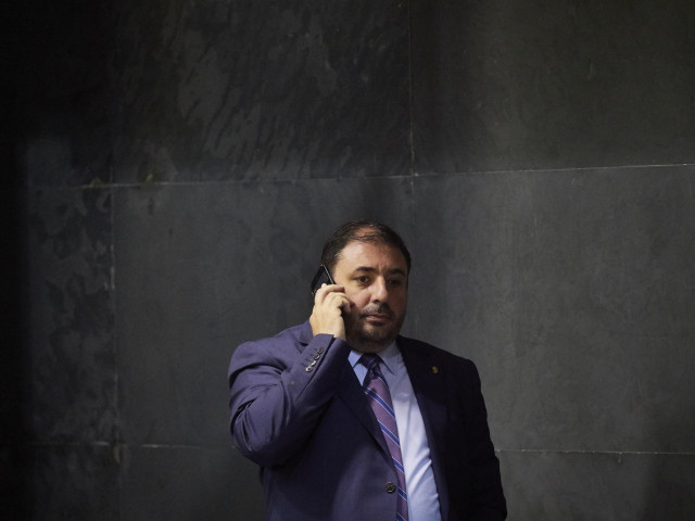 El presidente del PNV en Navarra, Unai Hualde, habla por teléfono a su llegada a una sesión plenaria en el Parlamento de Navarra.
