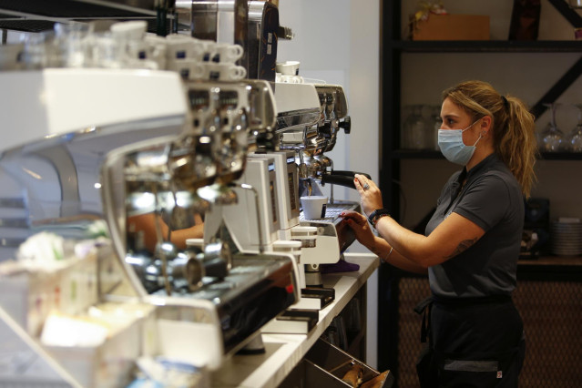 Una camarera sirviendo café en un bar de Granada, tras rebajar la Junta de Andalucía las restricciones anteriores que mantenían cerrado los negocios durante todo el día. A partir de este día los negocios se le permitirá abrir hasta las 18,00 horas. Granad