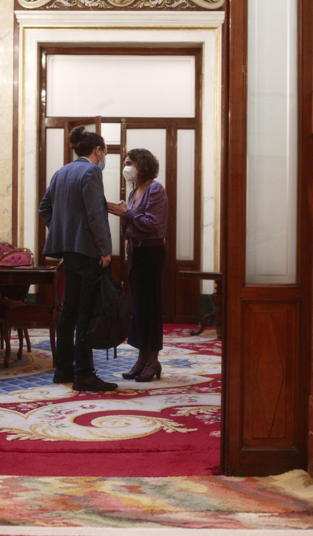 El vicepresidente del Gobierno, Pablo Iglesias y la portavoz del Gobierno y ministra de Hacienda, María Jesús Montero mantienen  una conversación durante una sesión de control al Gobierno, en Madrid (España), a 16 de diciembre de 2020.