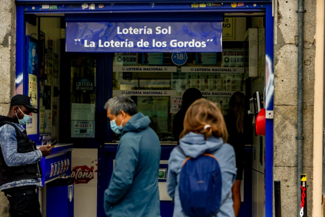 Varias personas hacen cola en las inmediaciones de la administración de lotería Sol donde venden boletos para el Sorteo Extraordinario de la Lotería de Navidad 2020, en Madrid (España), a 4 de noviembre de 2020.