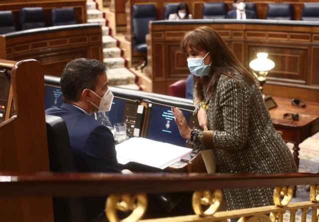 El presidente del Gobierno, Pedro Sánchez y la portavoz de JxCat en el Congreso y candidata del partido a las elecciones catalanas, Laura Borràs mantienen una conversación durante una sesión de control al Gobierno en el Congreso