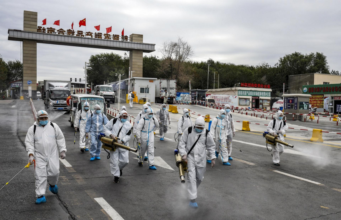 Un grupo de voluntarios en labores de desinfección de una vía en la ciudad de Urumchi en la región china occidental de Xinjiang.