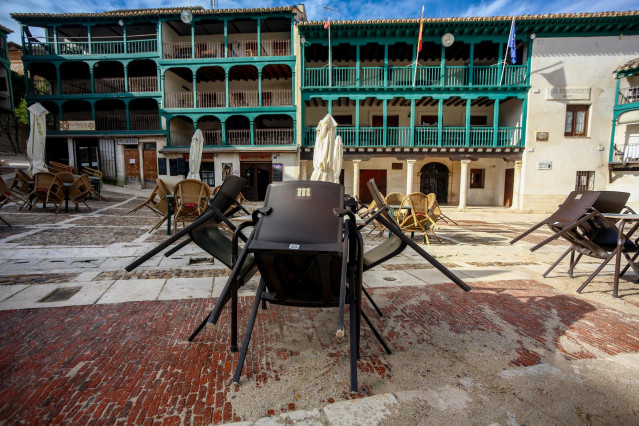 Sillas de locales de hostelería recogidas en la Plaza Mayor de Chinchón, un día antes de que el municipio sea confinado para frenar la expansión del coronavirus el pasado mes de noviembre