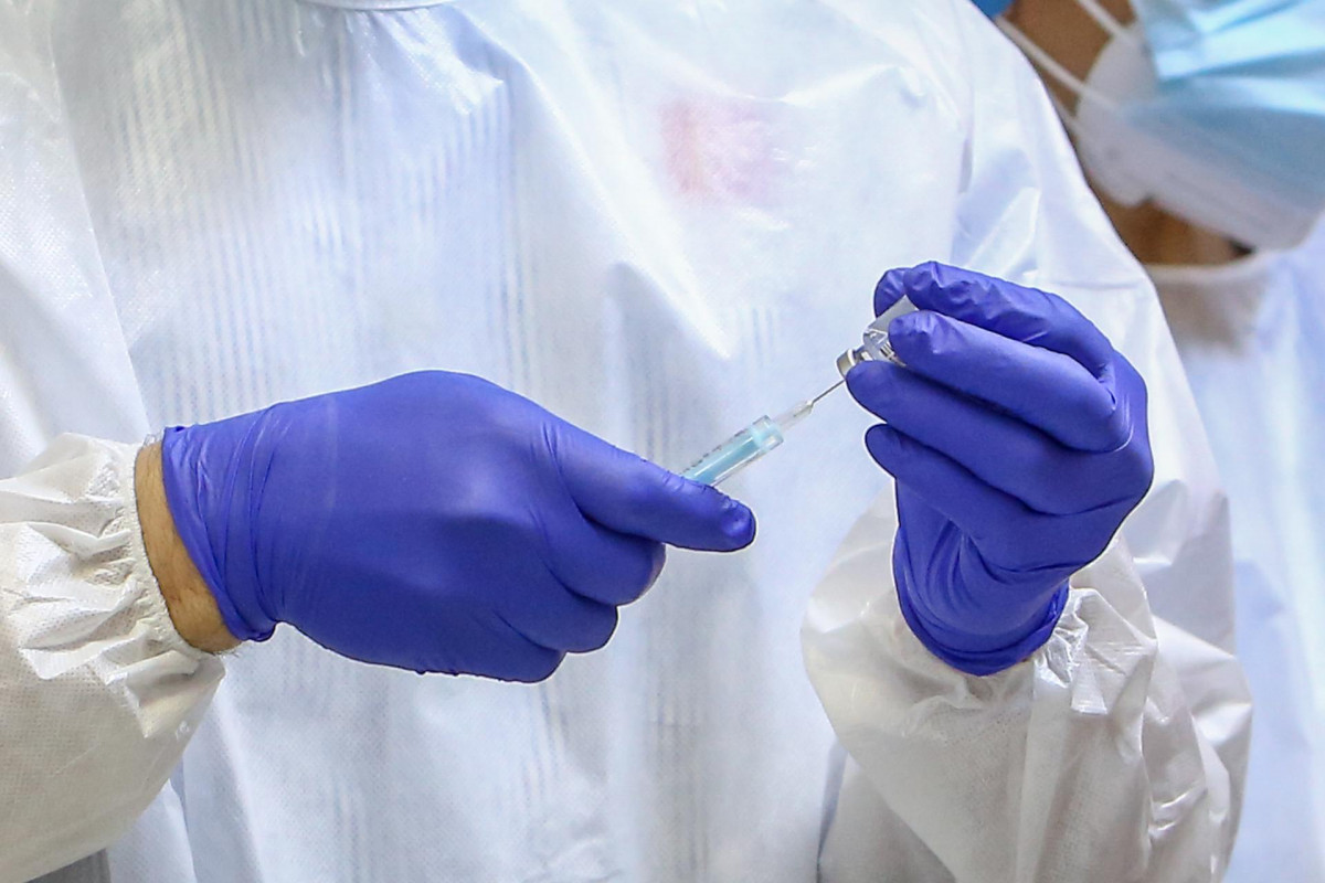 Un sanitario inyecta la vacuna durante el primer día de vacunación contra la Covid-19 en España, en la residencia de mayores Vallecas.