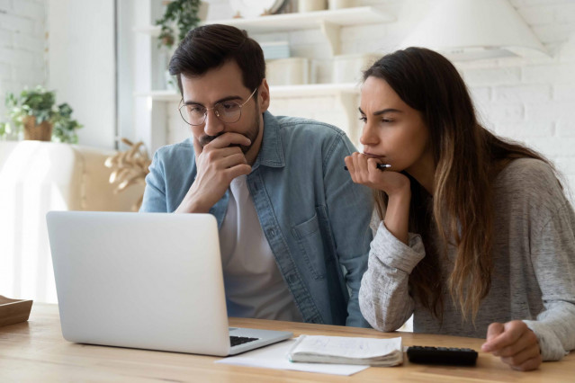 Dos jóvenes buscando vivienda en un ordenador