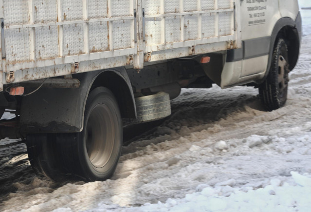 Un camión se queda atascado en una calle por el hielo en Madrid (España).