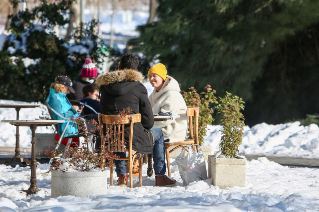 Varias personas en terrazas de bares entre la nieve en Pozuelo de Alarcón, Madrid (España) a 11 de enero de 2021. Madrid afronta hoy el primer día laborable en la región tras la gran nevada provocada por el paso de la borrasca ‘Filomena’. Numerosas calles