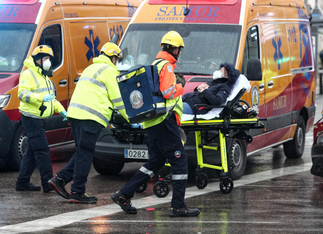 Varios trabajadores sanitarios trasladan a un herido momentos posteriores a una fuerte explosión registrada la calle Toledo
