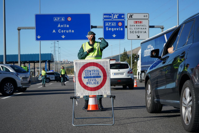Un agente de la Guardia Civil le da el alto al conductor de un vehículo durante un control de movilidad en una autopista
