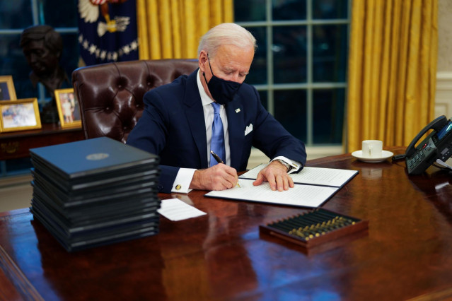 El presidente de Estados Unidos, Joe Biden, firma sus primeros decretos en el Despacho Oval.