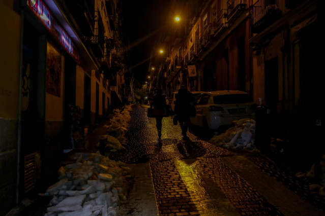 Un hombre y una mujer en una calle de Madrid de noche.