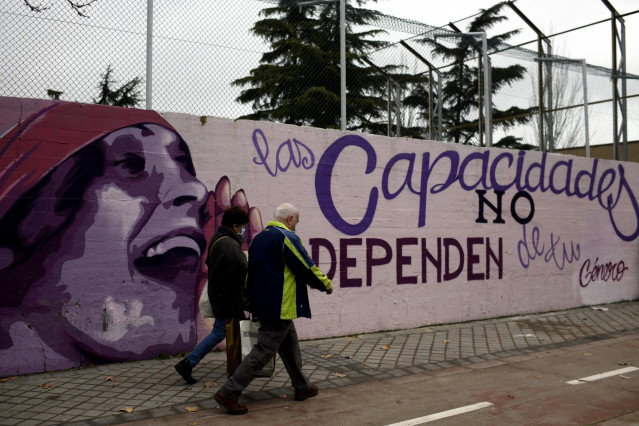 Dos personas pasan por el mural feminista en el polideportivo municipal de la Concepción en el distrito de Ciudad Lineal