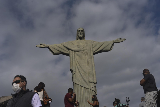 Personas con mascarilla por el coronavirus junto al Cristo del Corcovado de Río de Janeiro