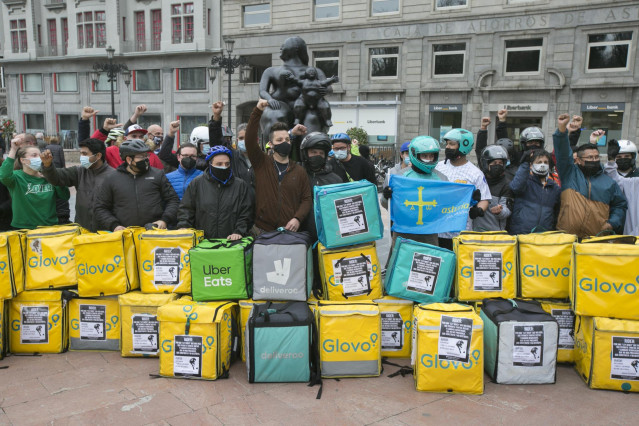 Varios repartidores acumulan sus mochilas tras haber participado en una pitada en sus vehículos, convocados por Repartidores Unidos y APRA en Oviedo.