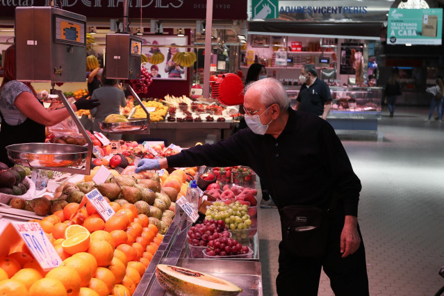 Archivo - Un cliente señala la pieza de fruta que quiere en una frutería del Mercado Central de Valencia