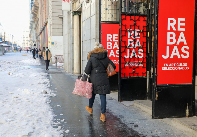 Archivo - Una mujer pasa por delante de un establecimiento durante el séptimo día de las rebajas de invierno, en Madrid