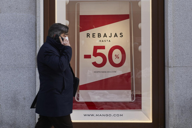 Archivo - Una persona pasa por delante de un establecimiento durante el séptimo día de las rebajas de invierno, en Madrid, (España)