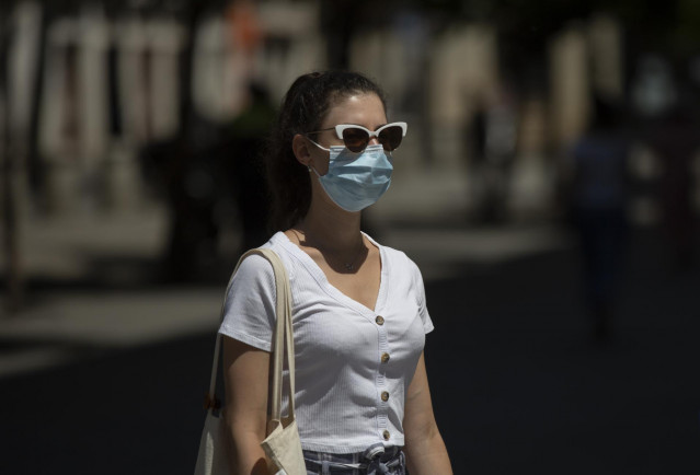 Archivo - Una mujer con mascarilla y gafas de sol  durante el quinto día de la fase 2 en Sevilla (Andalucía, España), a 29 de mayo de 2020.