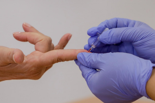 Archivo - Personal sanitario saca sangre de un dedo a una persona para realizar el test rápido de detección de anticuerpos IgG e IgM