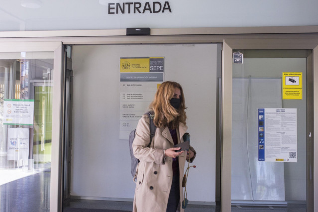 Una mujer entra por la puerta de una oficina del SEPE