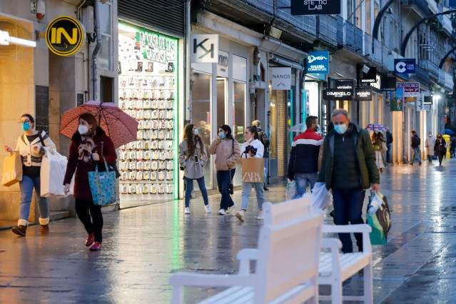 Archivo - Varias personas pasean en una calle comercial en una jornada marcada por el inicio de la entrada en vigor de una desescalada gradual en la región, en Vigo, Galicia (España)