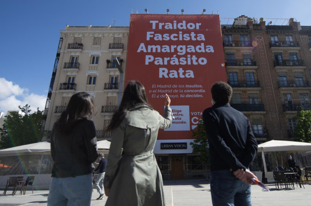 La presidenta de Ciudadanos, Inés Arrimadas; la vicealcaldesa de Madrid, Begoña Villacís; y el candidato de Cs a la Presidencia de la Comunidad de Madrid, Edmundo Bal, frente a la lona desplegada en la plaza Felipe II de Madrid.