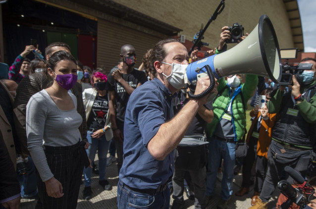 La ministra de Igualdad y el candidato de Unidas Podemos a la Presidencia de la Comunidad, Pablo Iglesias con un megáfono se dirige al público durante un acto del partido en el Polideportivo municipal Cerro Buenavista de Getafe,  a 27 de abril de 2021, en