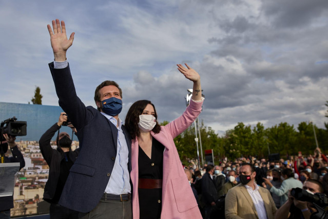El presidente del PP, Pablo Casado y la presidenta de la Comunidad de Madrid y candidata a la reelección, Isabel Díaz Ayuso saludan a su llegada al último acto de campaña del partido, en el barrio de Salamanca