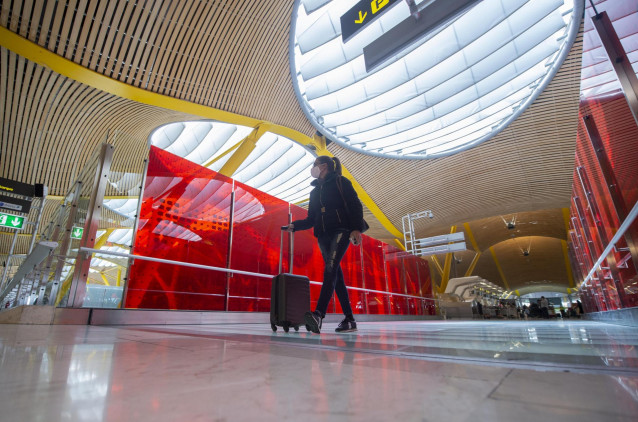 Archivo - Una pasajera desplaza su maleta por las instalaciones de la T4 del Aeropuerto Adolfo Suárez Madrid-Barajas