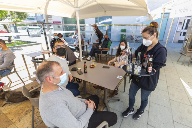 Una camarera sirve en una terraza del municipio de O Grove durante el primer fin de semana de apertura del cierre perimetral