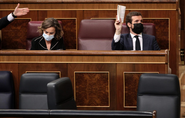 Archivo - El líder del PP, Pablo Casado, muestra la Constitución Española durante su intervención en una nueva sesión de control al Gobierno