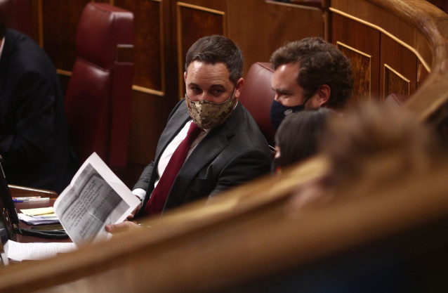 (I-D) El líder de Vox, Santiago Abascal; el portavoz parlamentario de Vox, Iván Espinosa de los Monteros; y la portavoz adjunta de Vox en el Congreso, Macarena Olona, conversan durante una sesión plenaria en el Congreso