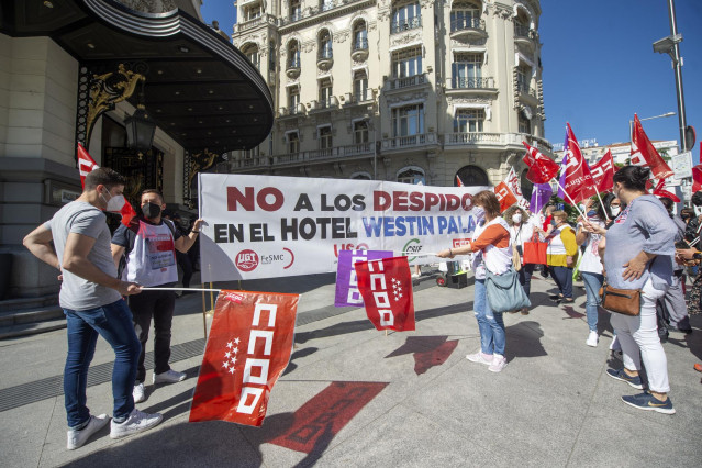 Empleados del Westin Palace acuden a una concentración con una pancarta donde se puede leer 