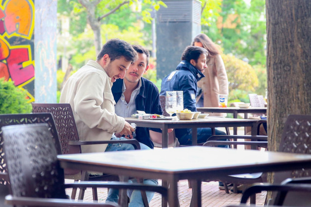 Varias personas en la terraza de una cafetería en la plaza de Olavide en el barrio de Chamberí