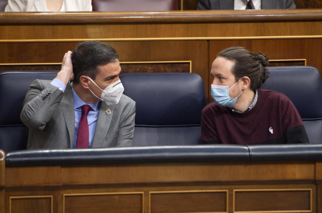 Archivo - El presidente del Gobierno, Pedro Sánchez, conversa con Pablo Iglesias
