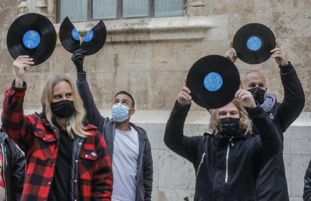 Varios Dj de la Comunidad Valenciana sostienen discos como signo de protesta durante una concentración