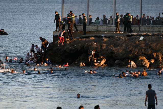 Personas migrantes en la playa del Tarajal, a 17 de mayo de 2021, en Ceuta (España). España ha movilizado al Ejército en la ciudad tras la entrada de más de 5.000 marroquíes en 24 horas.