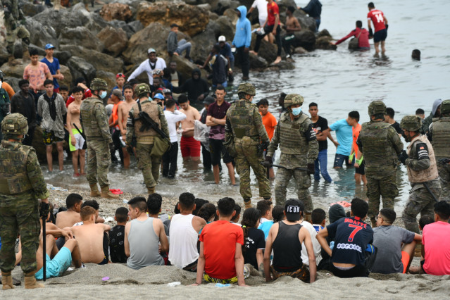 Militares del ejército español vigilan durante las devoluciones en caliente que están efectuando a los migrantes que han entrado en Ceuta procedente de Marruecos