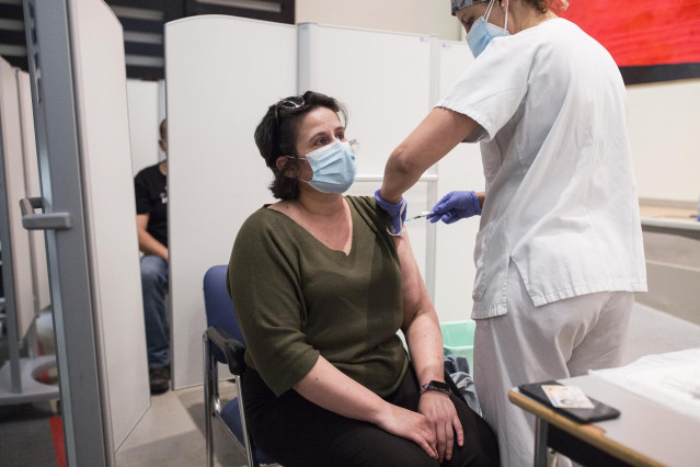 Una sanitaria administra la primera dosis de la vacuna de Pfizer a una mujer en el Hospital Universitario de Getafe (Madrid).