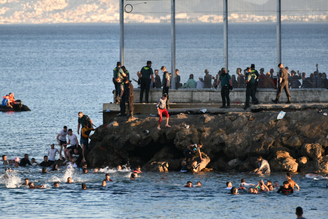Personas migrantes en la playa del Tarajal, a 17 de mayo de 2021, en Ceuta (España). España ha movilizado al Ejército en la ciudad tras la entrada de más de 5.000 marroquíes en 24 horas.