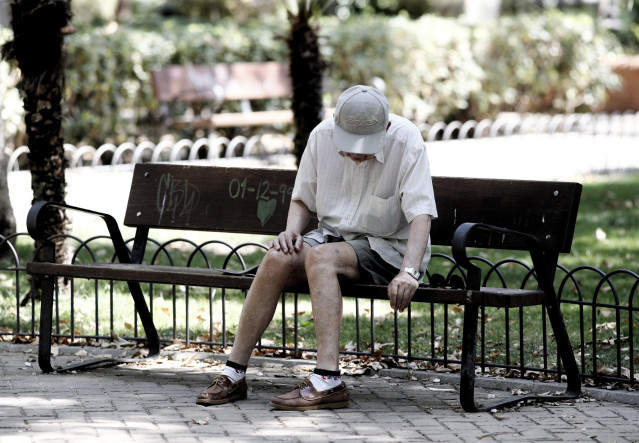 Archivo - Un pensionista descansa en un banco de un parque de Madrid.